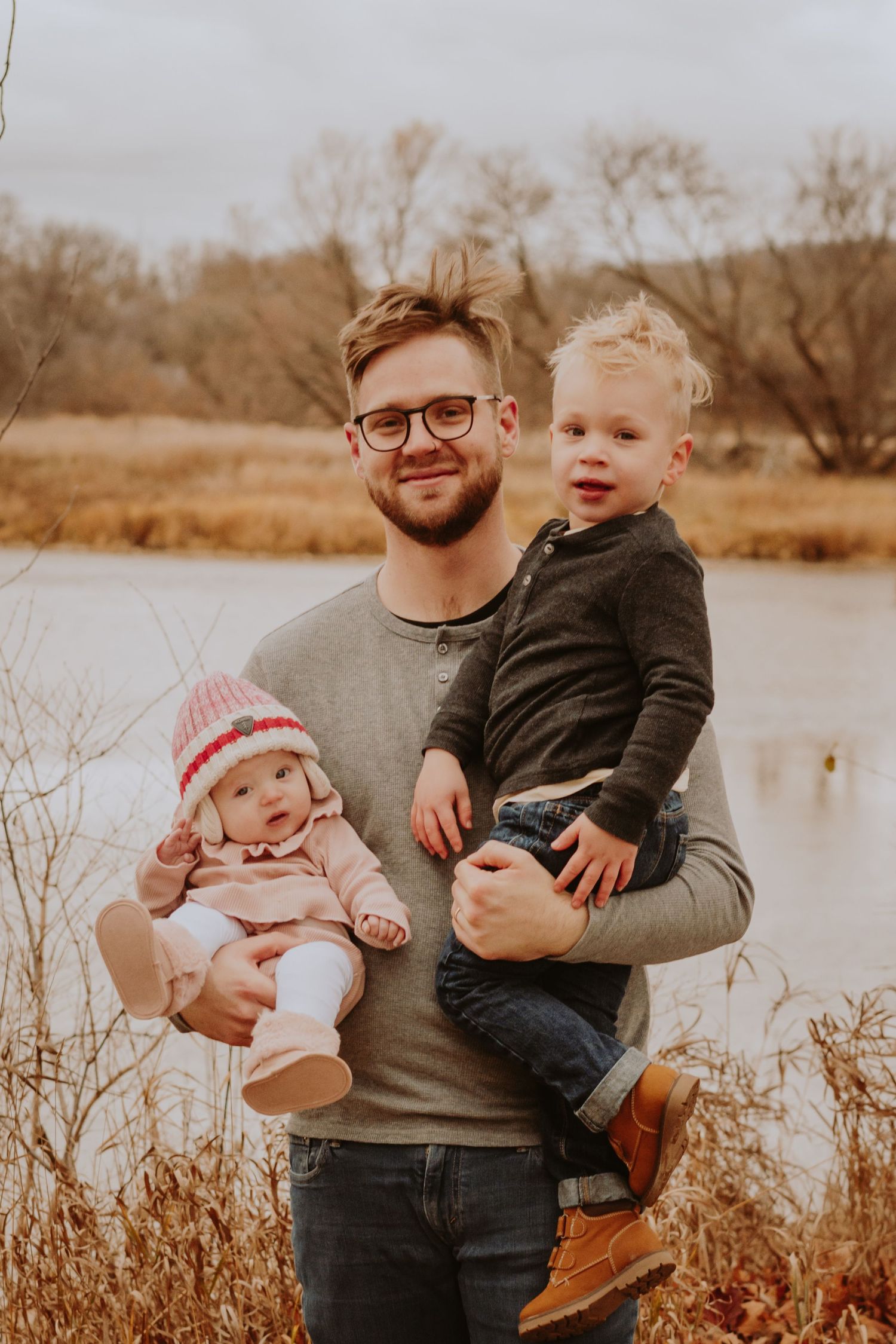 Image of dad and children in front of water.
