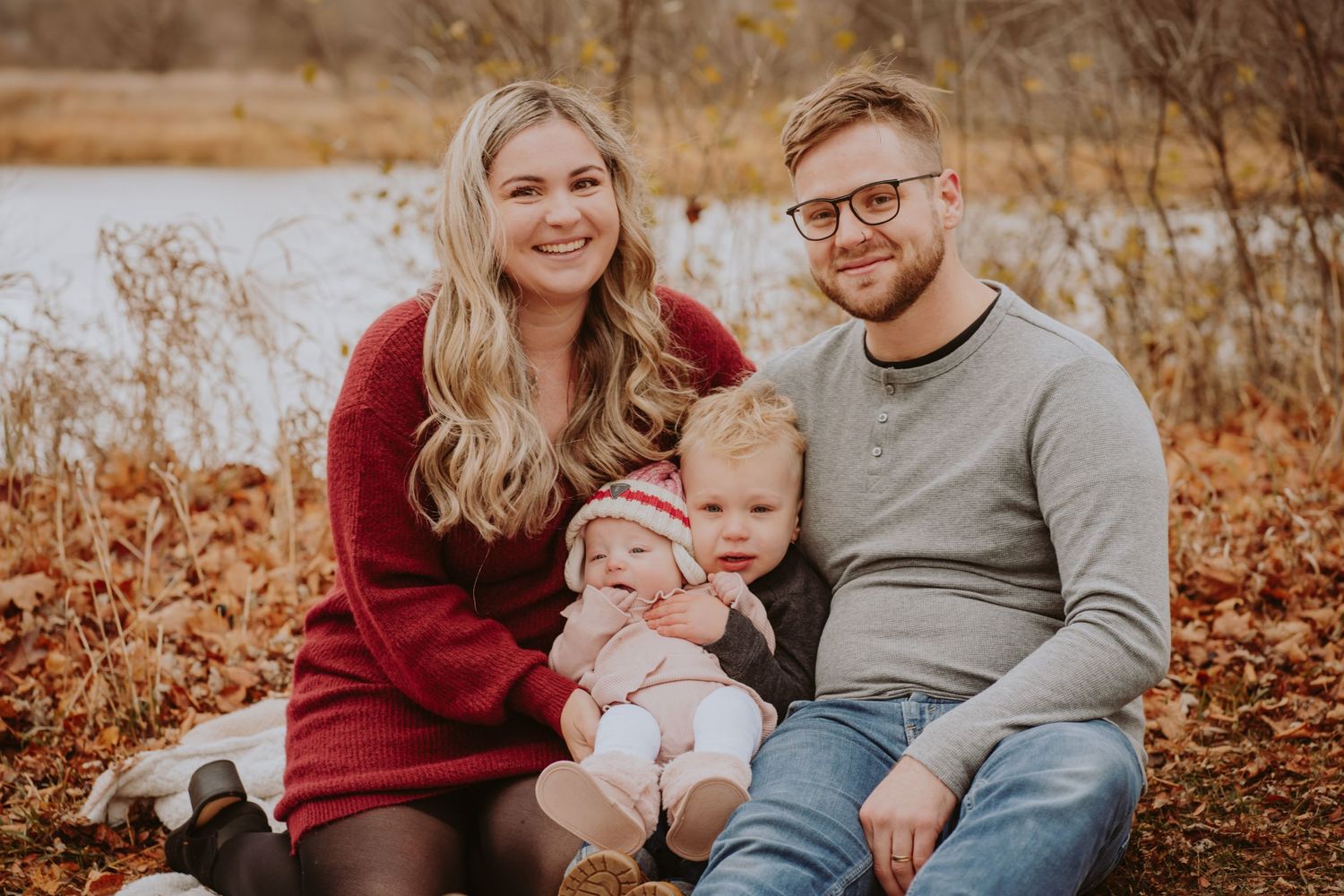 Image of family sitting in front of water.