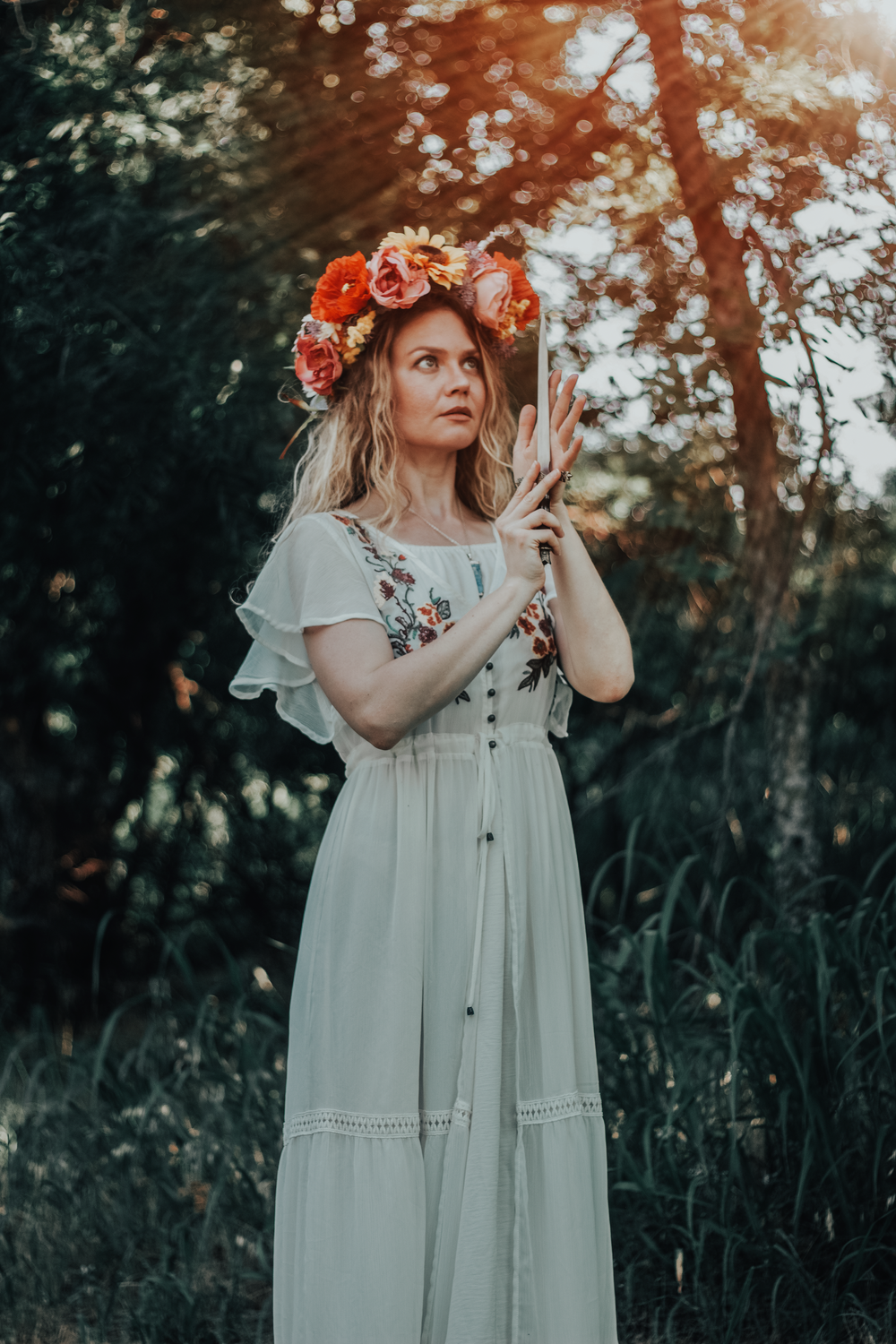 Dreamy sunset portrait in white dress with coral flower crown in natural woodland setting.