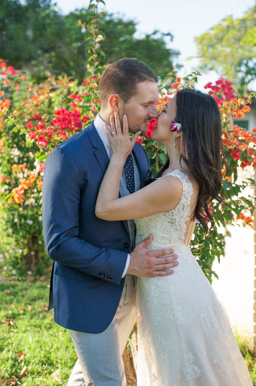 Bride and Groom kissing in front of bouganvilla