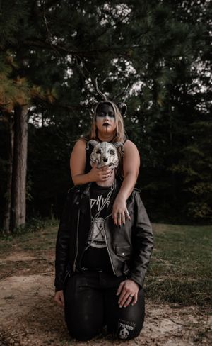 Dark gothic photoshoot in a forest setting featuring dramatic poses and spooky masks.