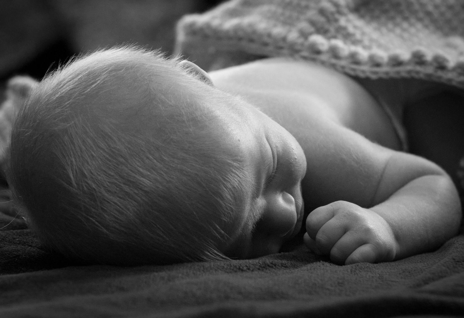 Newborn baby boy snuggled in his handmade blanket from his grandmother in his home near Ponca, NE.