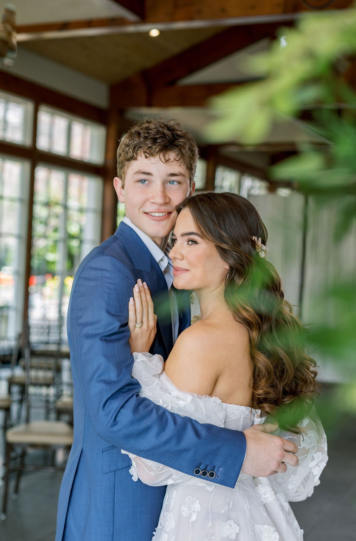 Romantic wedding portrait in an indoor venue with natural lighting and lace details.