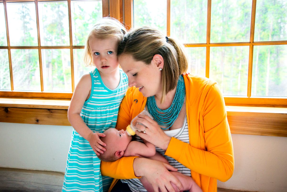 Mother and toddler daughter holding baby brother