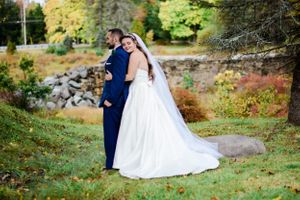 Wedding couple posing in autumn foliage and natural outdoor scenery.