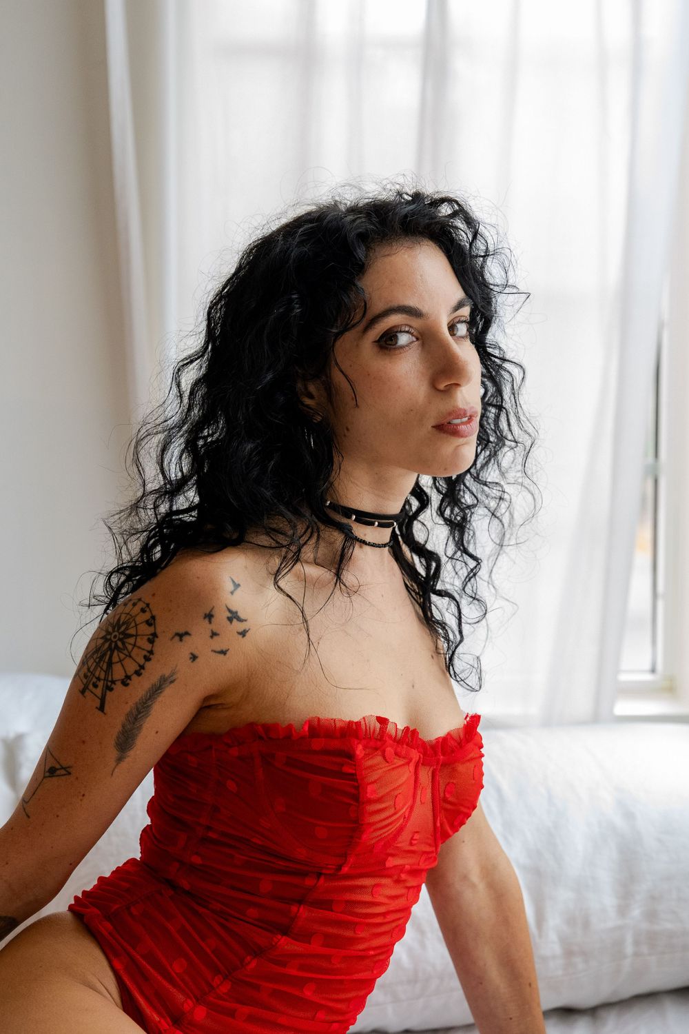 Boudoir session with model wearing red corset lingerie in Charlottesville, Virginia.