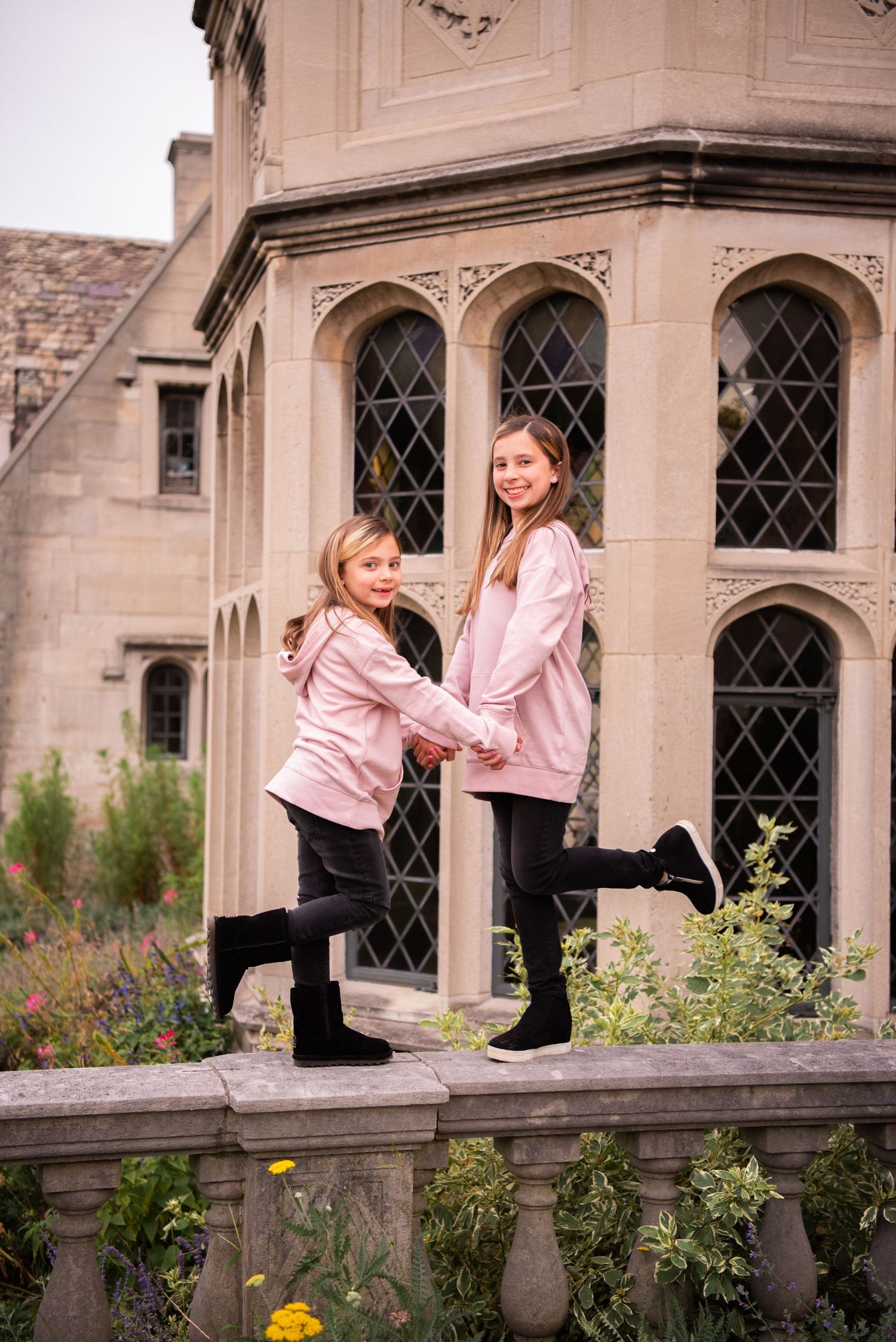 two sisters holding hands standing in front of hartwood acres mansion