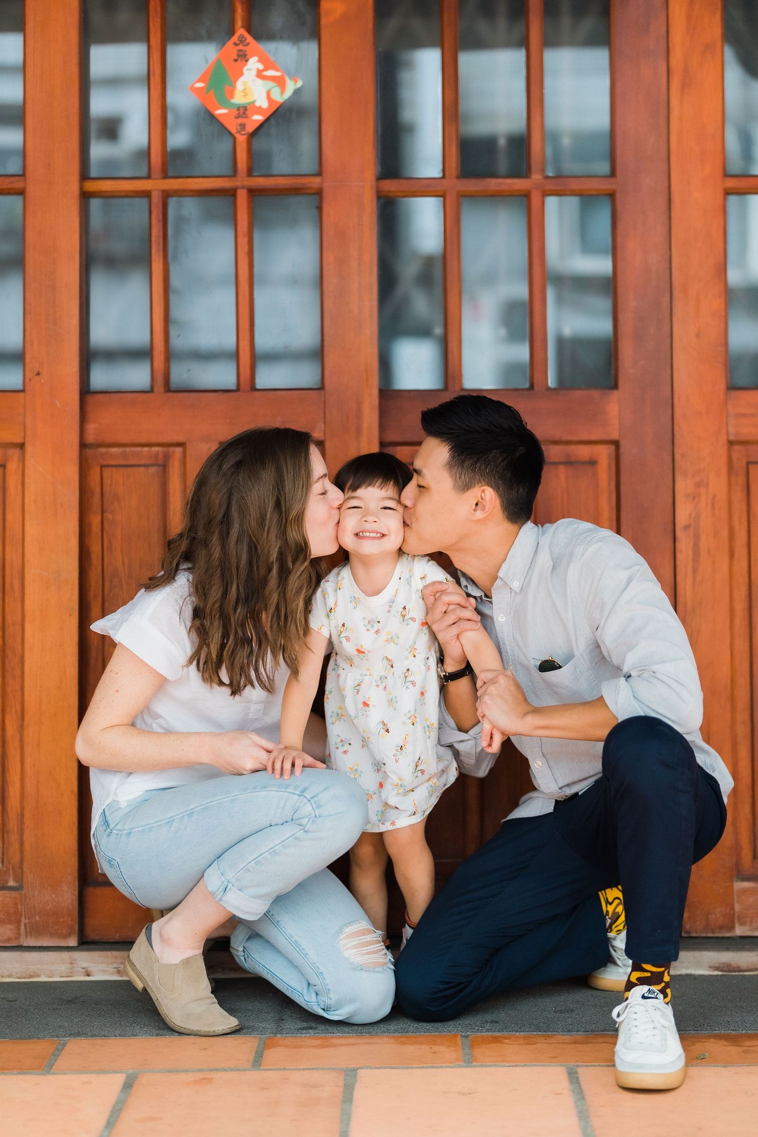 A family shares a tender moment together in front of wooden doors.