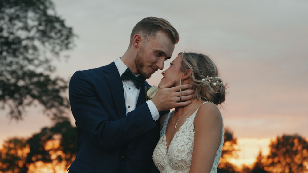 Romantic sunset wedding portrait with couple embracing in golden light.