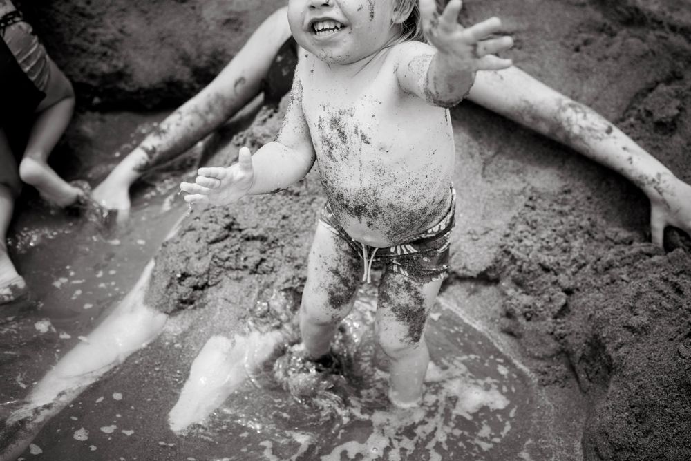 Boy playing with the wet sand at best family photo session Malaga