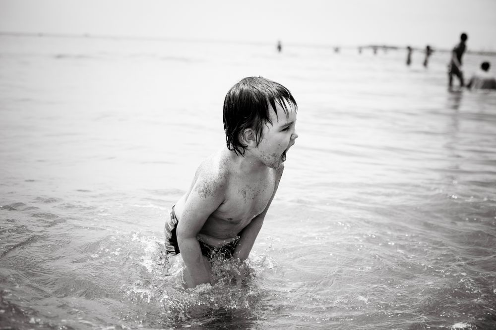 Boy in the water at family photo session Malaga