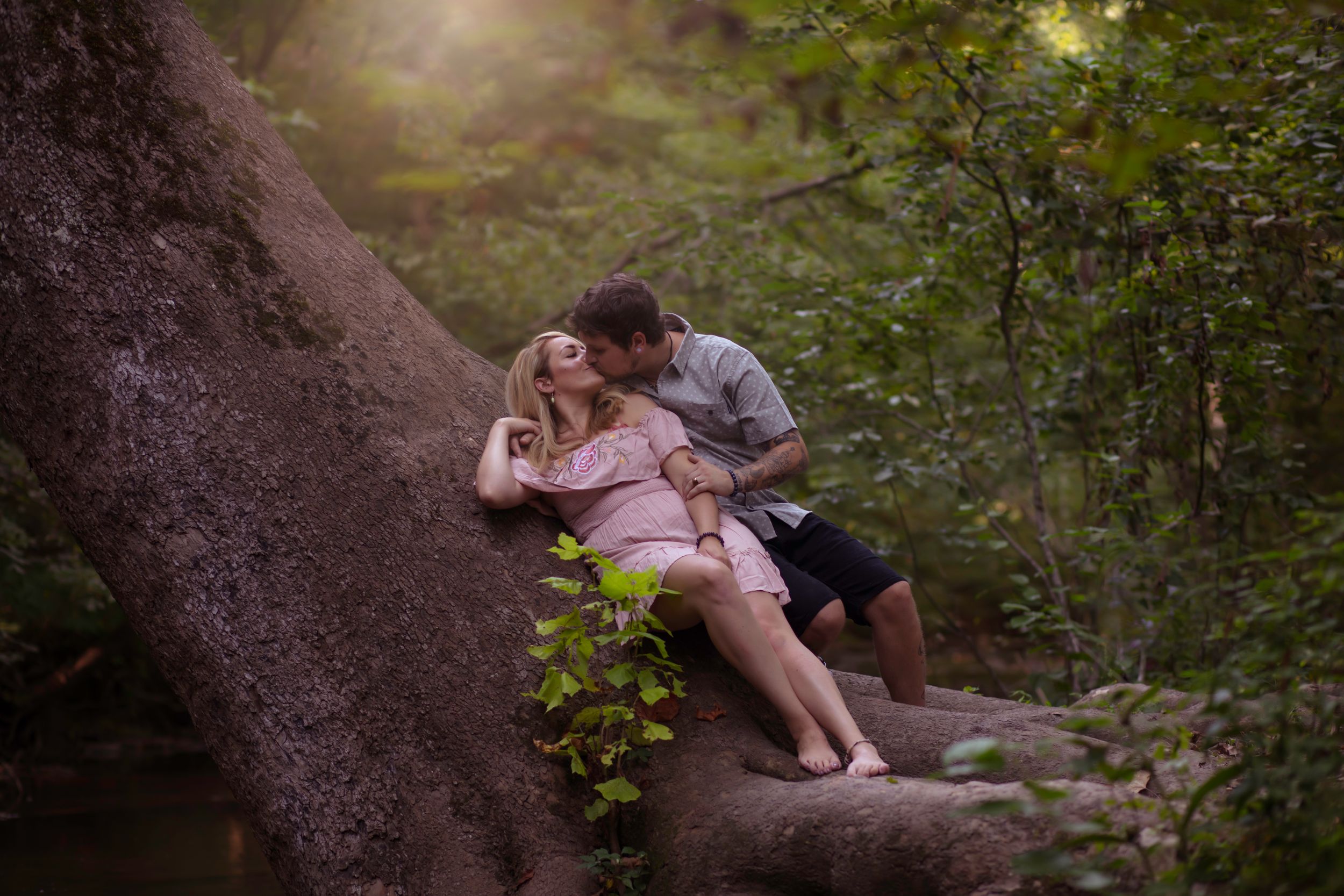 A romantic outdoor photoshoot in a natural wooded setting during golden hour.