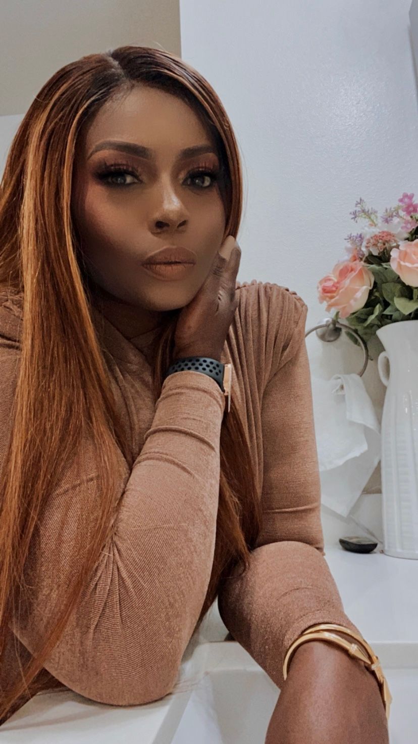 Model wearing a brown sweater poses in front of white wall with floral decor in a series of portrait shots.