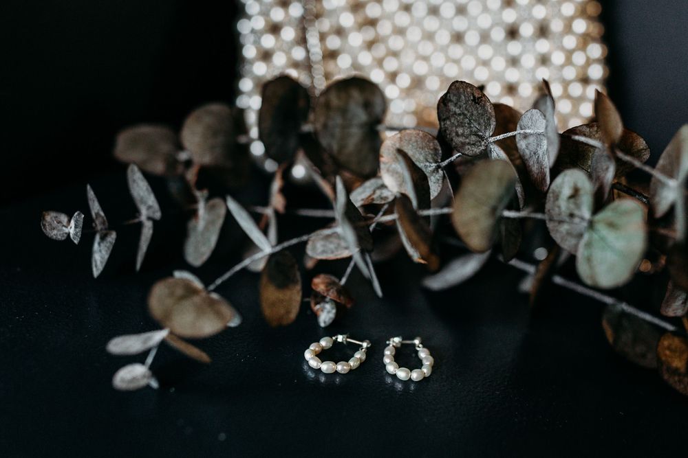 Pearl and crystal wedding jewelry and accessories arranged on a dark background.