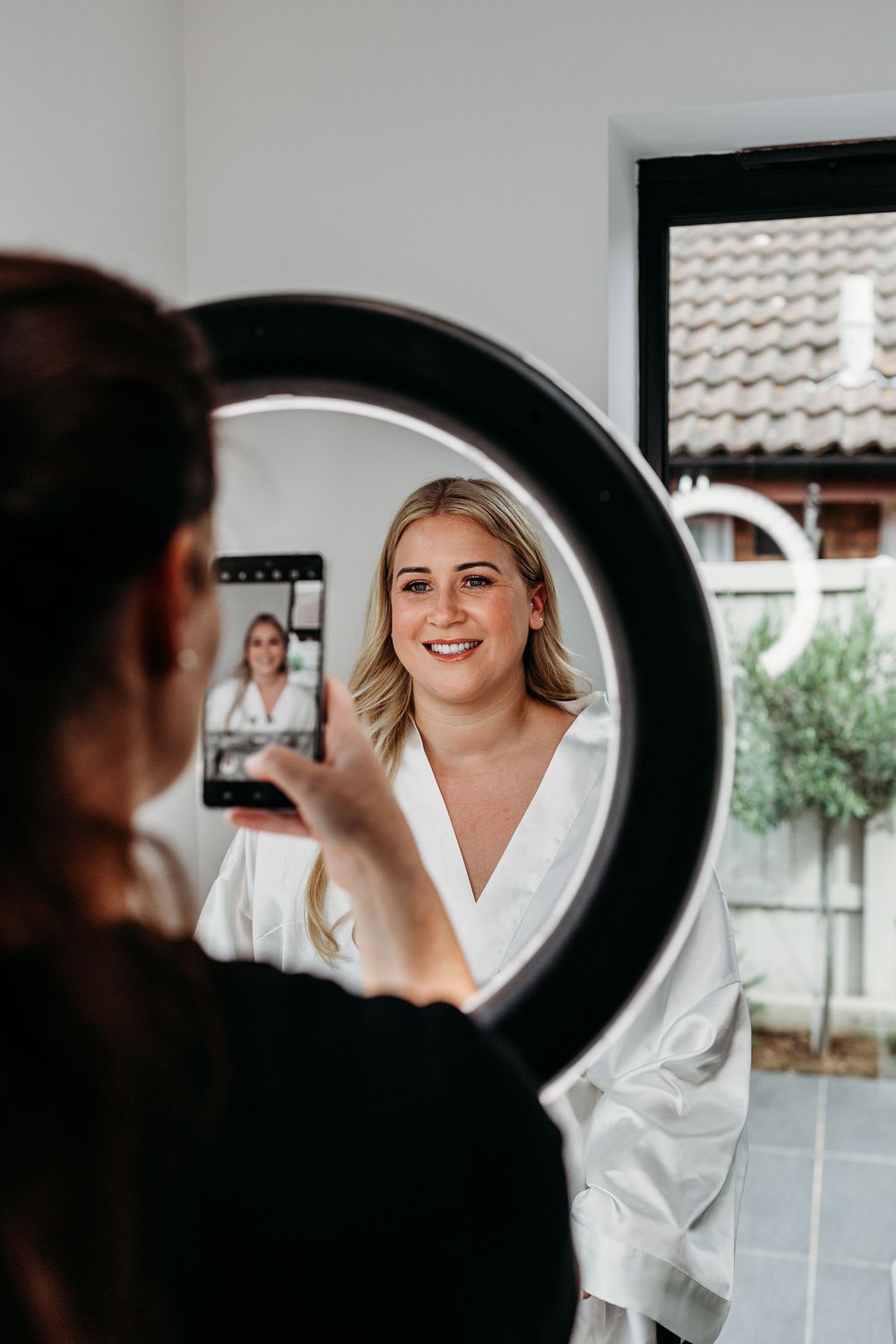 Behind the scenes wedding preparation photo with ring light reflection in mirror.