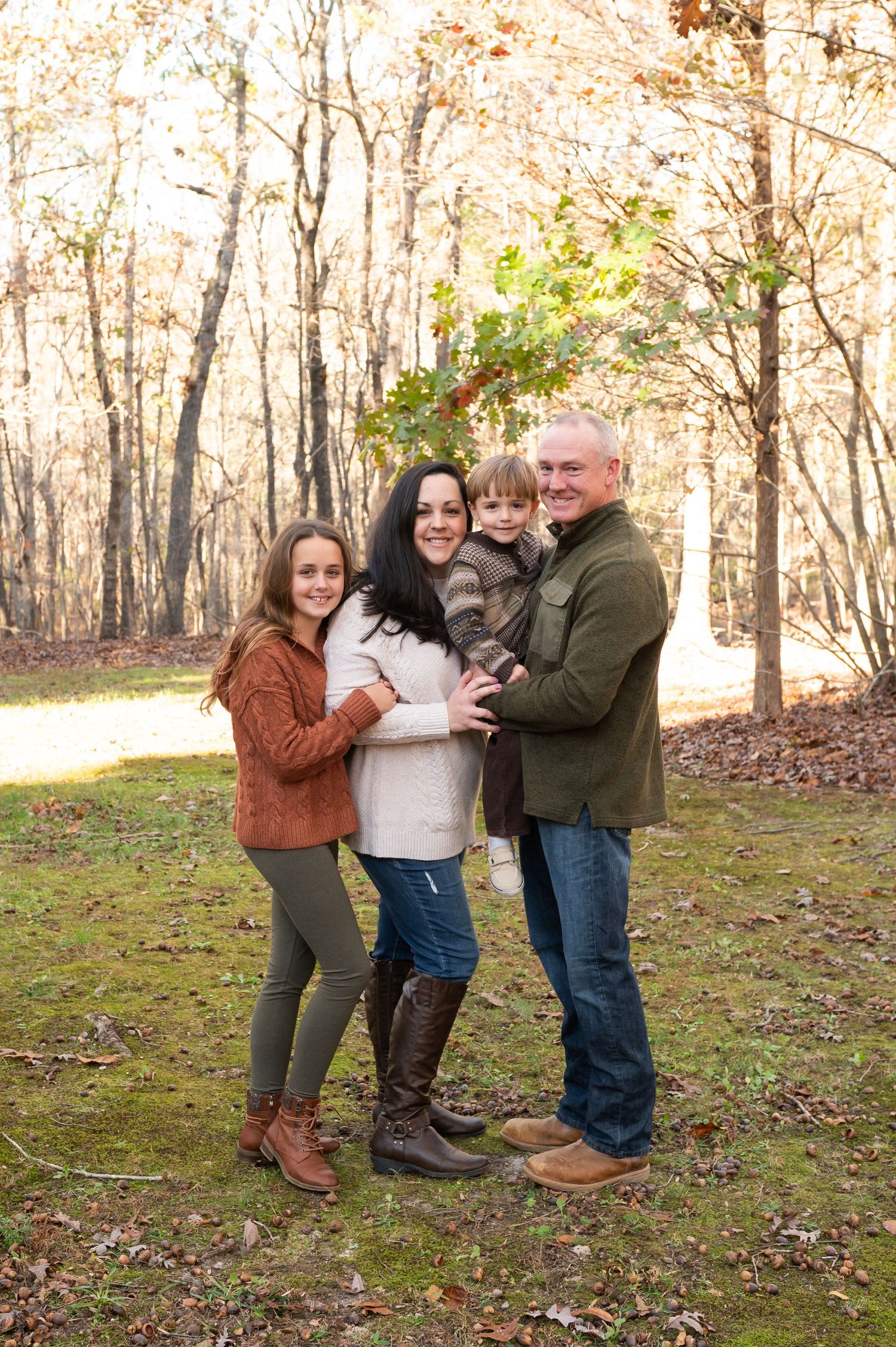 Family having fun together in an autumn forest setting with fallen leaves.