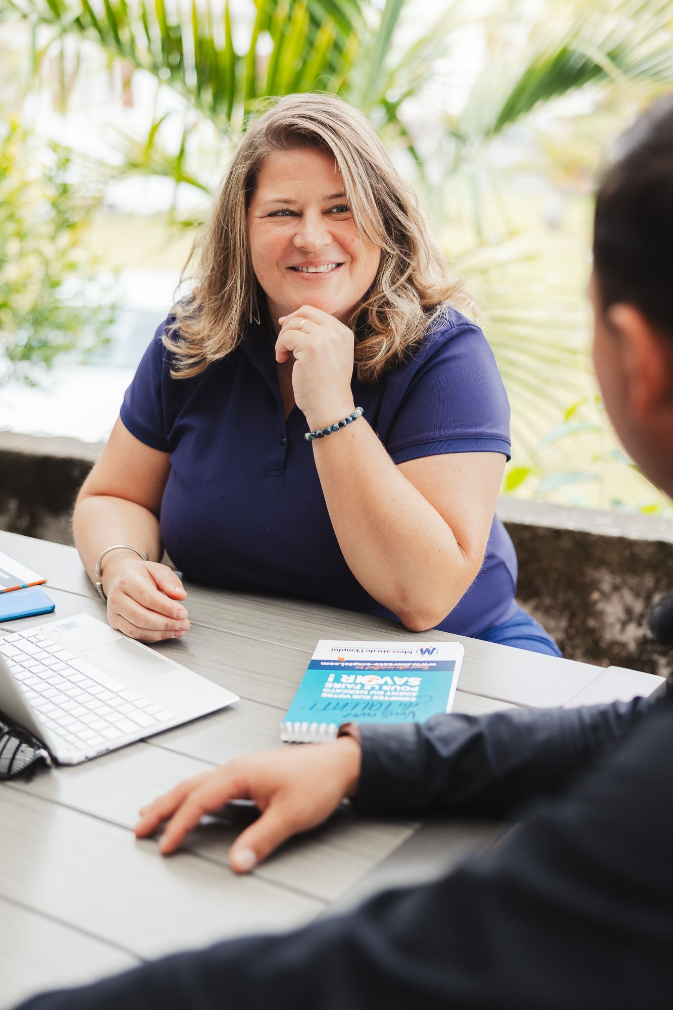 Business meeting scene at a table with laptop and documents.