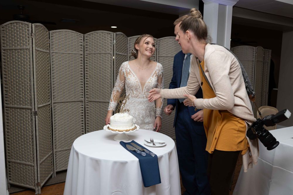 Wedding guests sharing a lighthearted moment while serving cake at the reception.