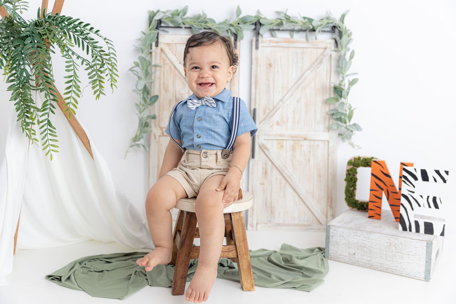 Studio setup with rustic barn doors, ferns, and farmhouse-inspired decor.