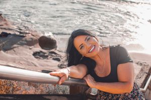 Candid shots of someone laughing while posing on coastal steps at sunset.
