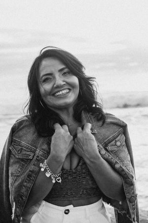 Black and white portrait series capturing authentic expressions and joy near the ocean.