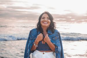 Beachside fashion photography with relaxed poses against ocean backdrop at sunset.