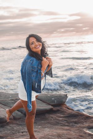 Casual coastal photoshoot featuring denim and white outfit combinations with natural seaside backdrop.