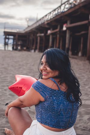 A carefree beach photoshoot featuring blue top and white shorts against a wooden pier background.