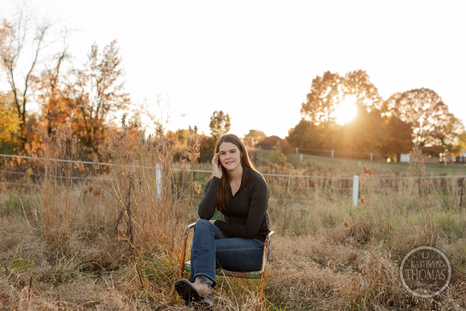 Golden hour portrait in field with sunburst through trees.