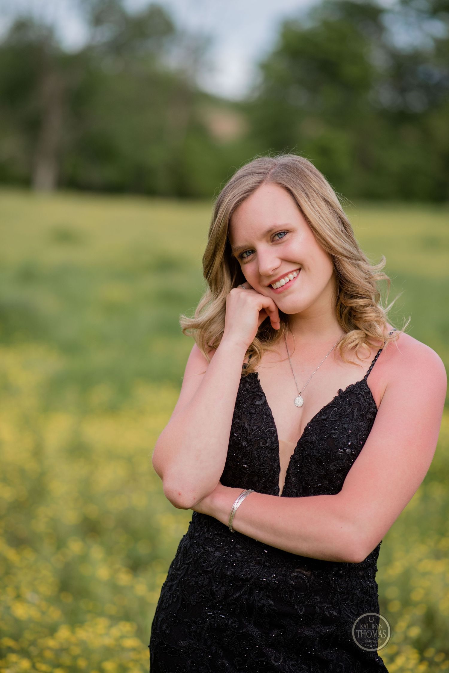 A figure in a sparkling black formal dress poses against a backdrop of yellow spring flowers.