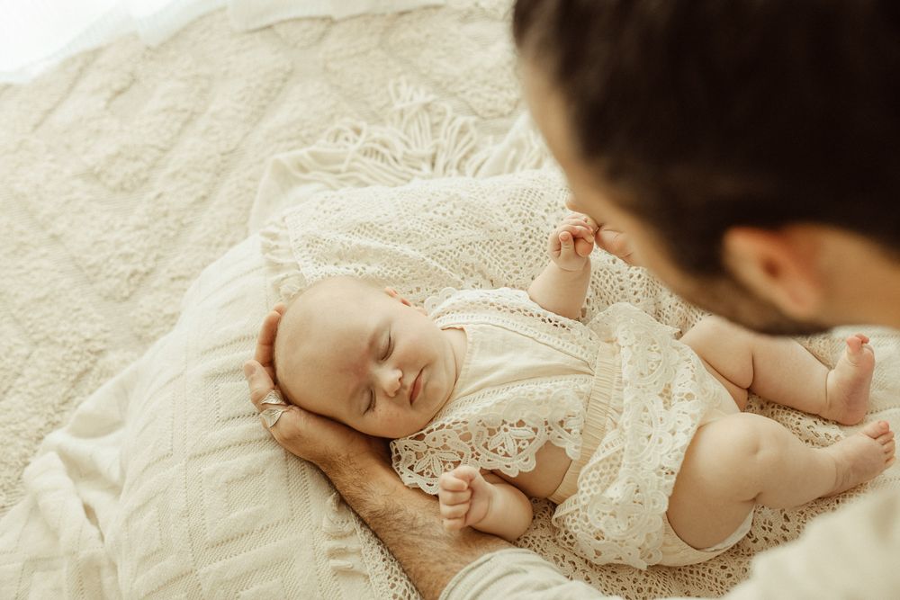 Peaceful newborn baby sleeping soundly on a textured blanket, the soft light casting a glow on the delicate features