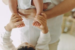 Older sibling holding the hands of a newborn, a touching moment of connection and tenderness between siblings