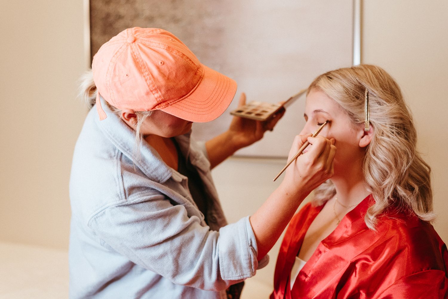 Professional makeup application being performed in natural lighting.
