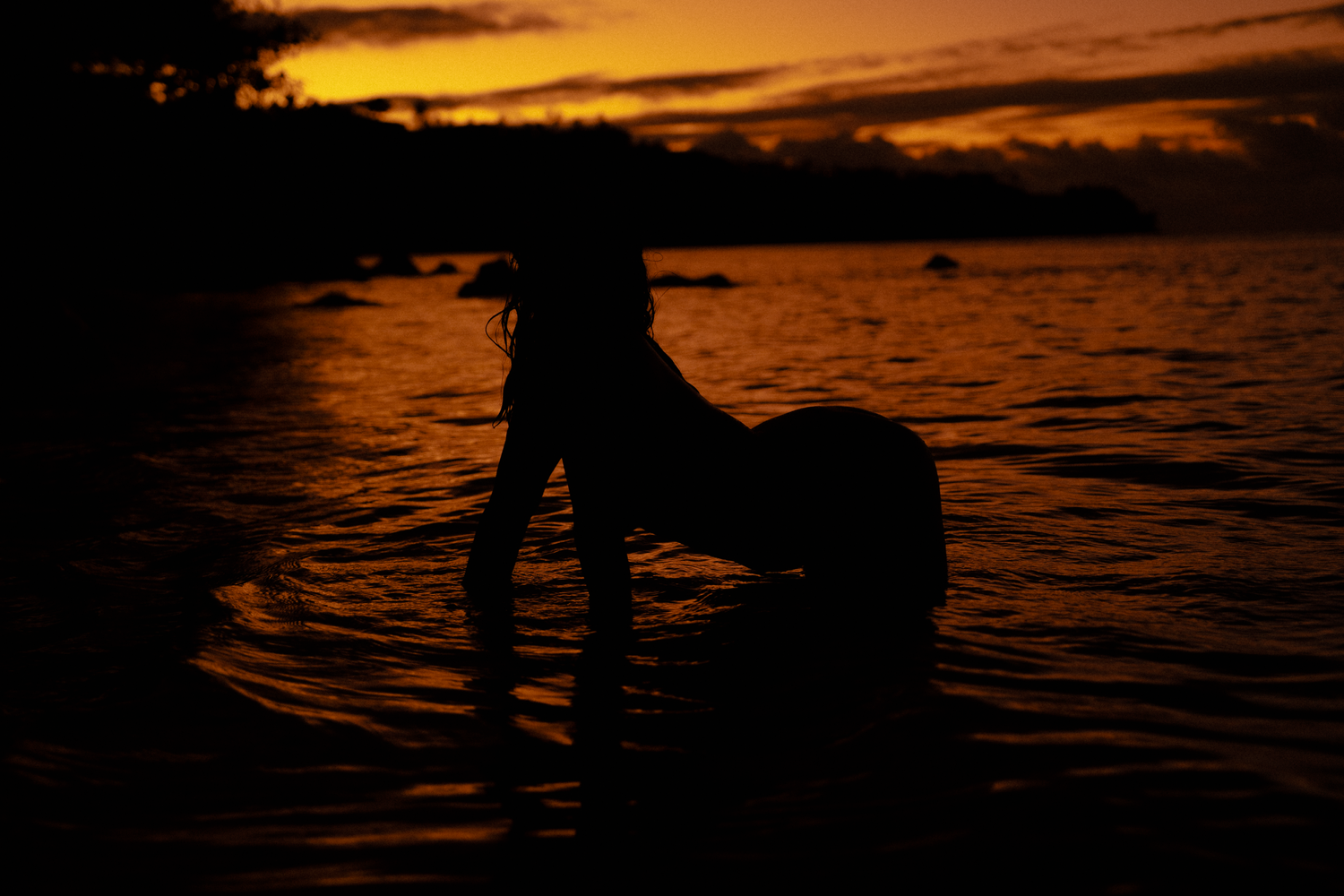 bouidor moment on the beach in the sand of Anini kauai during a firy sky sunset