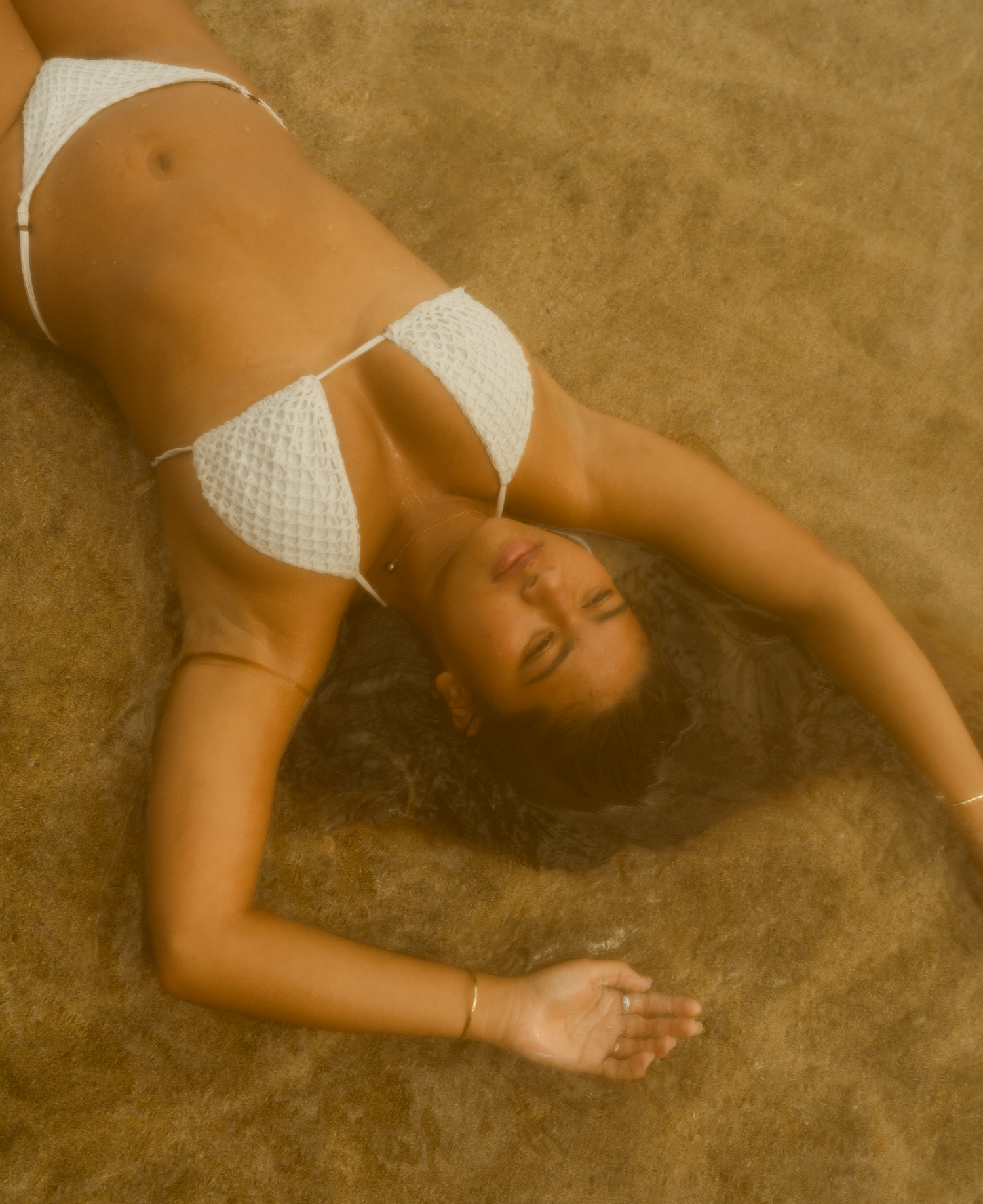 fun creative portrait of girl in the shallow waters of the beaches shores of Hawaii