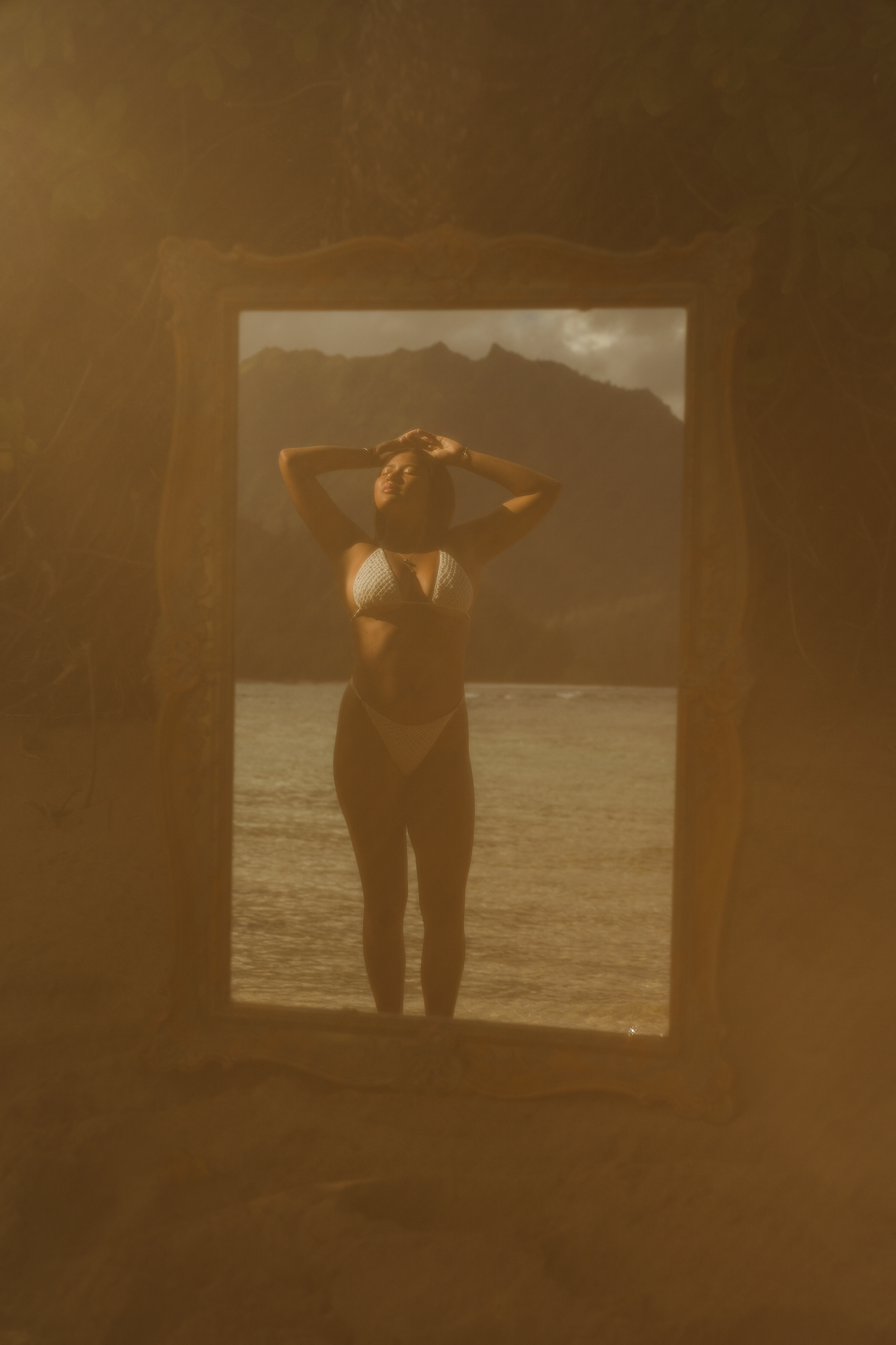 girl standing in a mirror at he beach in Hawaii
