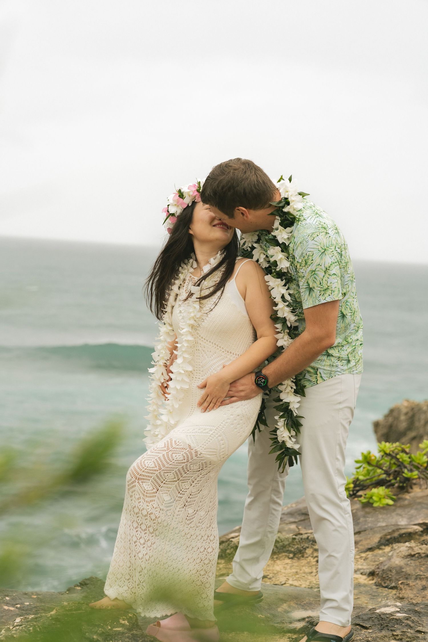 couples first kiss on a cliff of shipwrecks beach watching the sun set