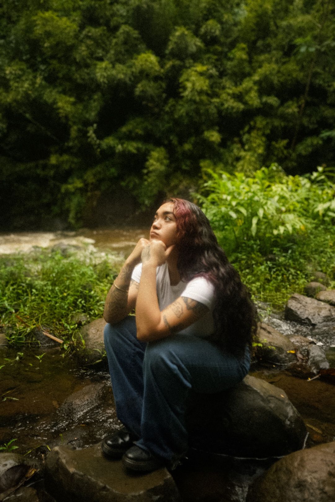 in the mountain near a river with a girl relaxing in her own thoughts