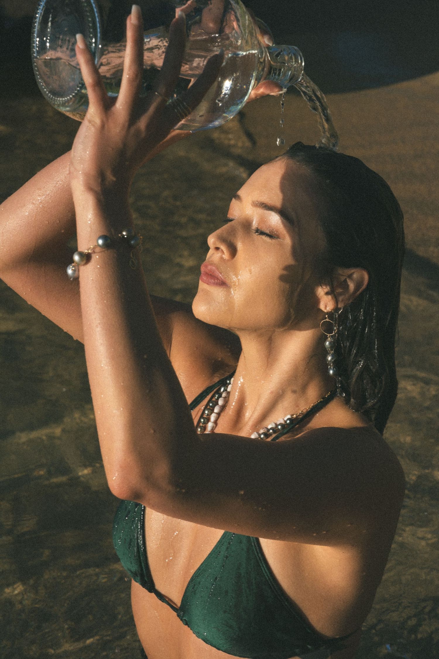 girl in water with pearls on, in Hawaii, kauai at lei-nani beach as the morning sun rises