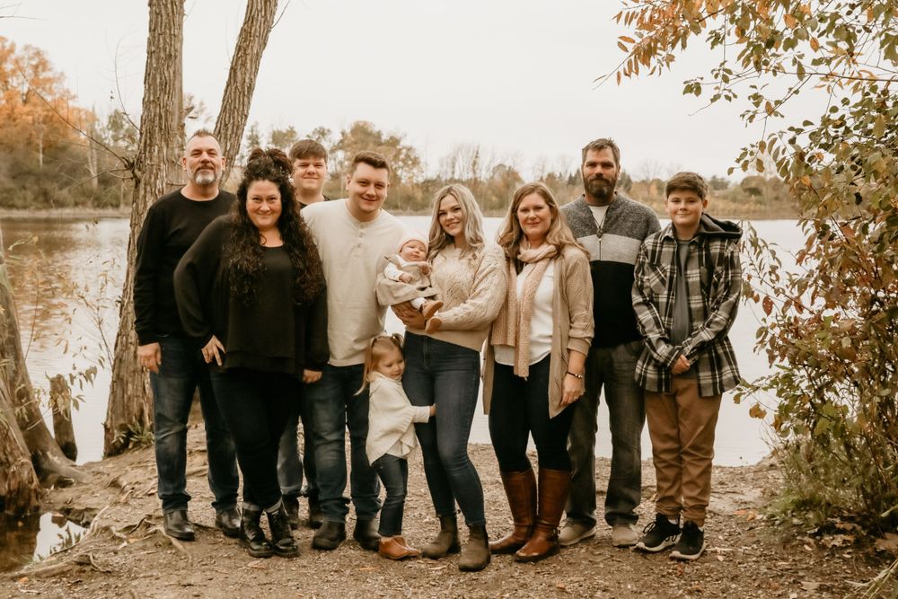 A family posing in front of a lake.