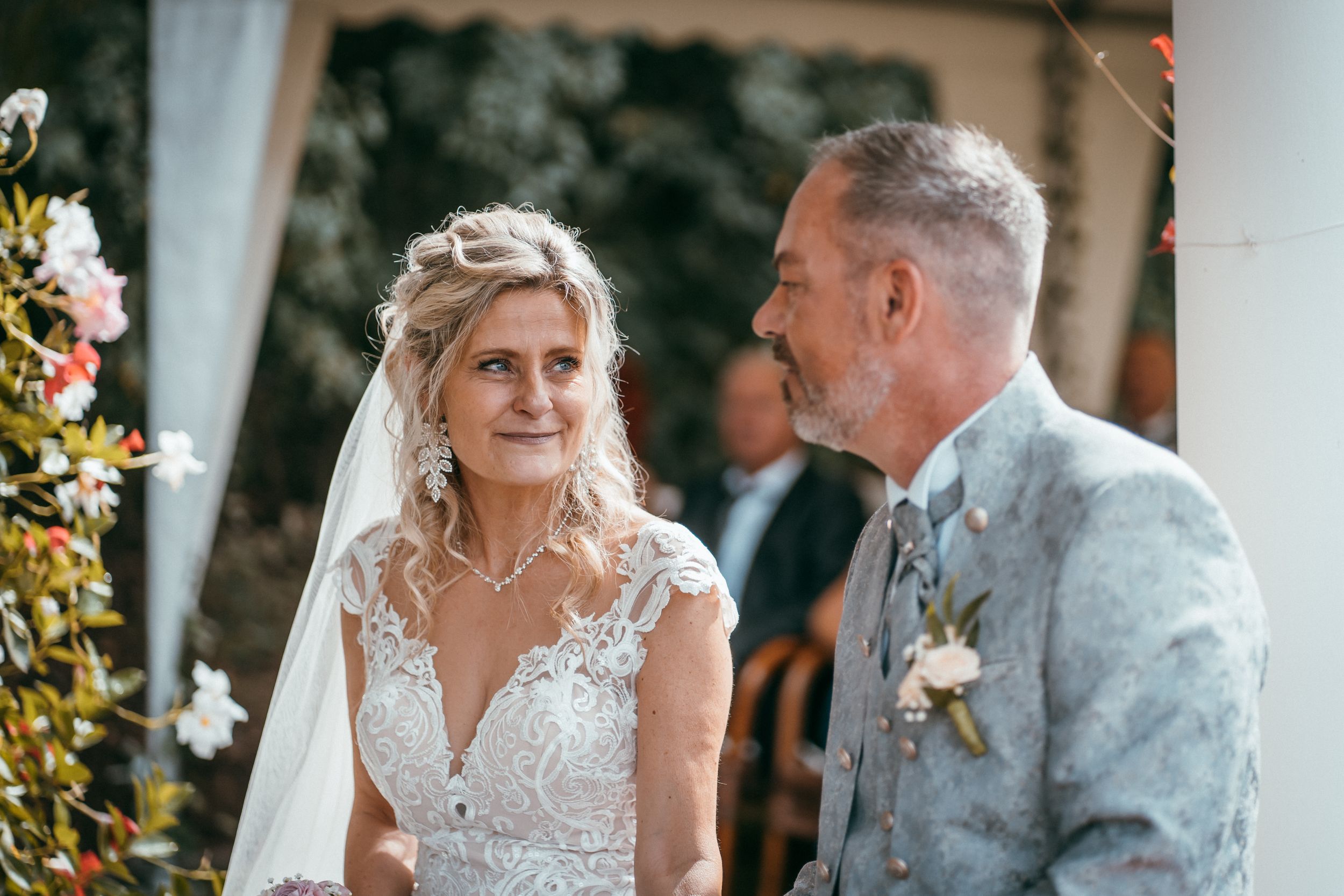Braut und Bräutigam blicken sich während der eleganten freien Trauung liebevoll an.