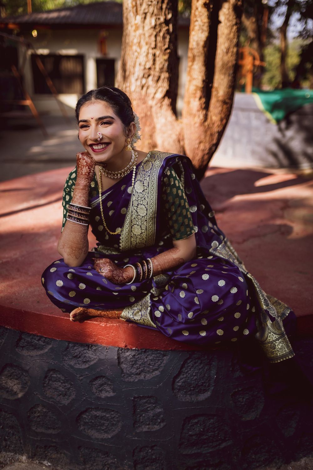 cool marathi bride sitting cross legged in her nauvari Saree.