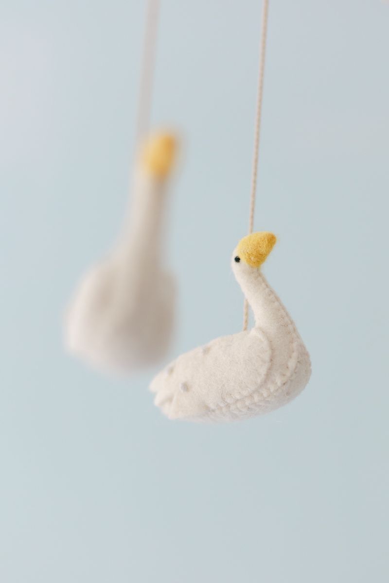 a felt stuffed swan against a blue backdrop photo by Paula Ortiz NY Family Photographer