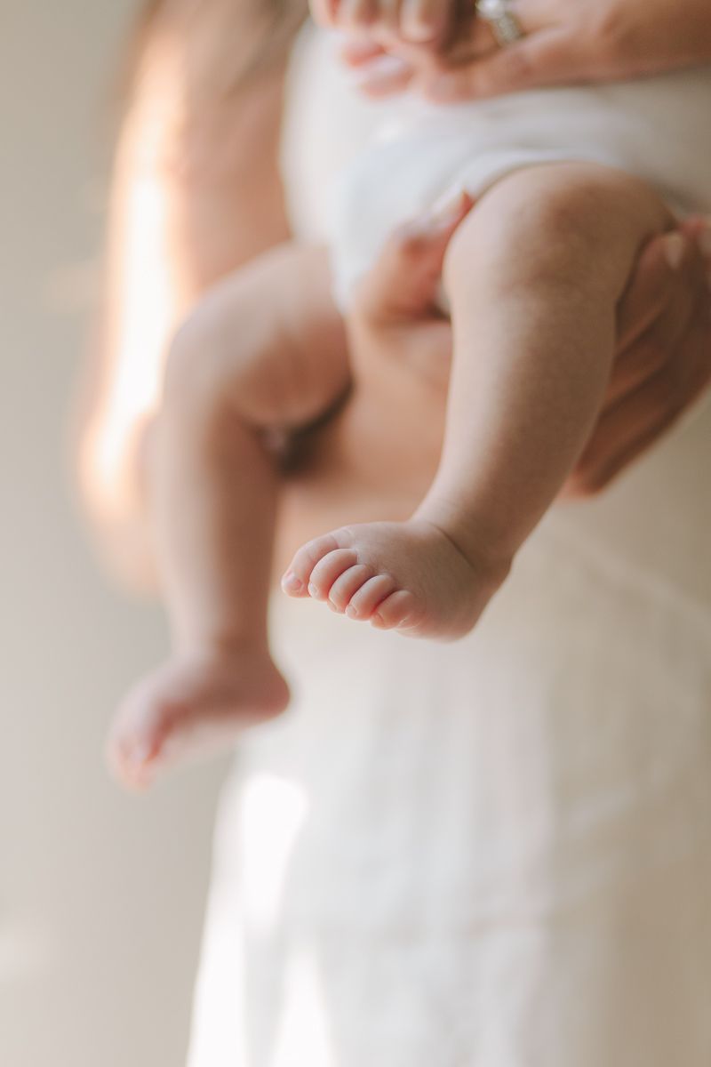a soft focus detail of a newborn child little feet with beautiful light photo by NYC Family Photographer Paula Ortiz
