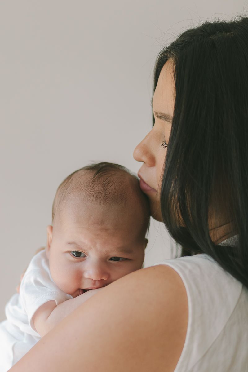 a candid moment of a woman's profile resting her chin on her newborn child in Forrest Hills Queens NY