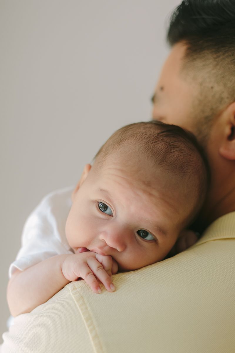 a newborn child resting on her father's shoulder photo by Paula Ortiz NYC Family Photographer