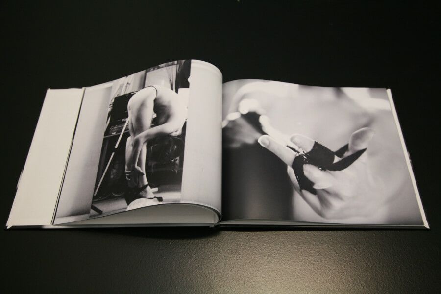 Fine art photography book showing dramatic black and white compositions with dynamic poses.