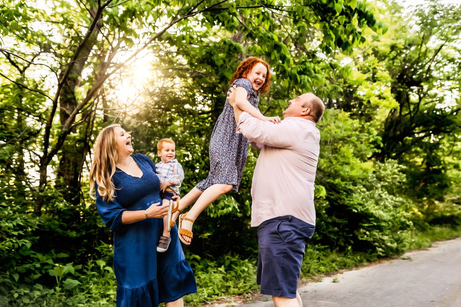 family portrait of four in front of trees
