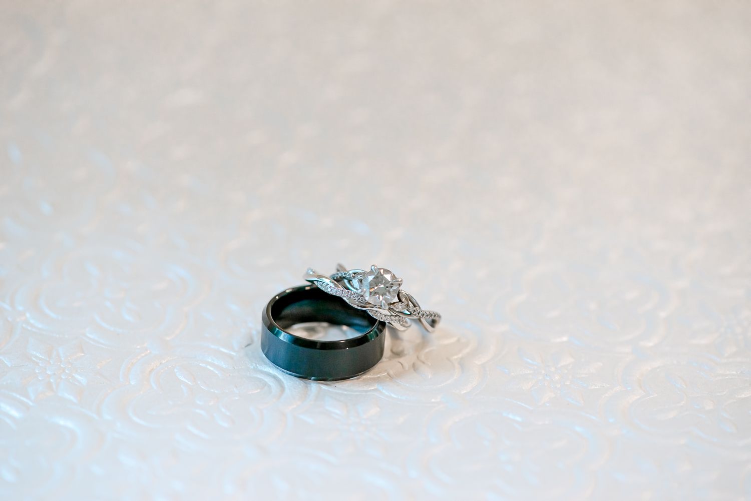 Elegant engagement ring photographed on textured white background.