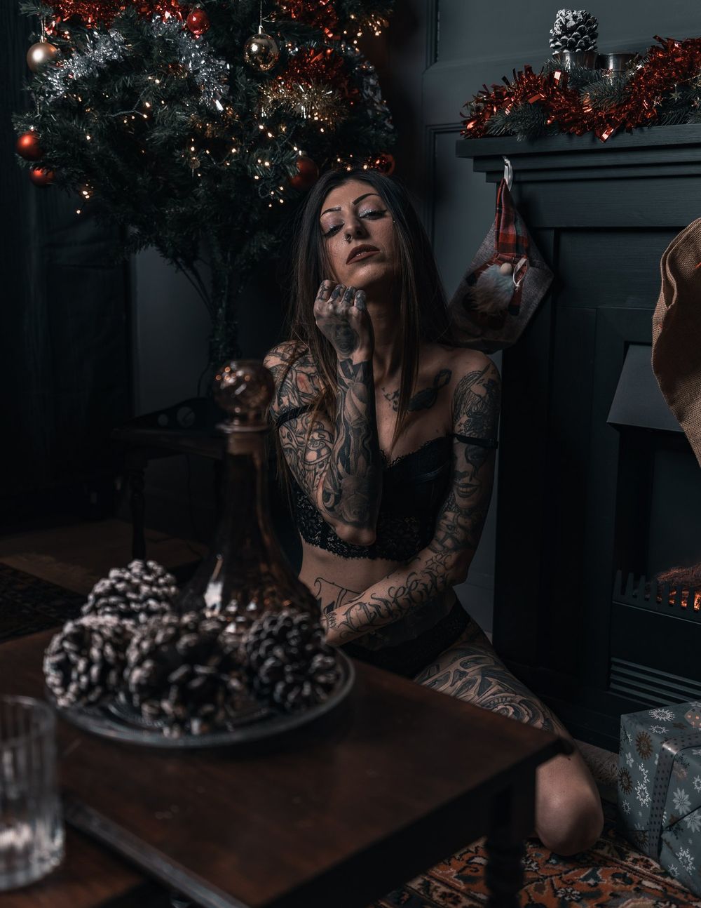 Atmospheric Christmas portrait with decorated tree and moody lighting.